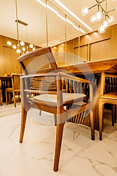 Vertical shot of wooden chairs and tables in a modern living room