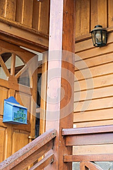 Vertical shot of a wooden house with a postal box and street