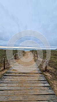 Vertical shot of a wooden walkway to the Rodiles beach