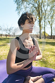 Vertical shot of a young Caucasian female doing yoga practice in the park