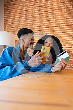 Vertical shot young couple shopping online with credit card and smartphone