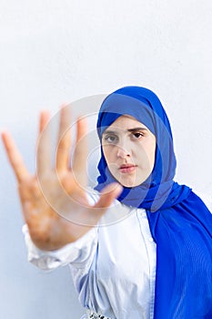 Vertical shot of a young muslim woman wearing hijab looking at c