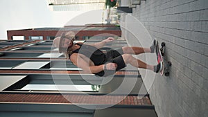 Vertical shot of the young skilful skater performing fast skateboard riding at urban city street