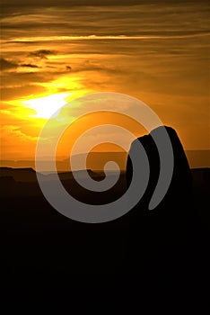 Vertical shpt of the silhouettes of rocks in Utah desert at sunset with yellow sky