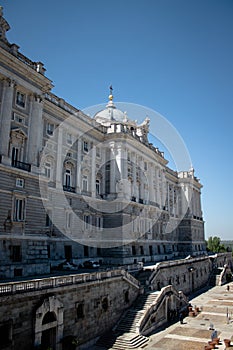 Vertical side shot of the Royal Palace of Madrid and police officers guarding the building