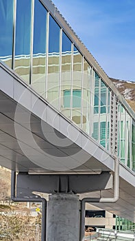 Vertical Skybridge connected to a modern building with mountain and blue sky background