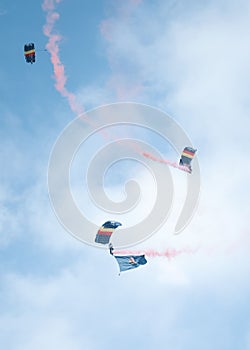 Vertical of skydivers diving with a parachute from the cloudy sky