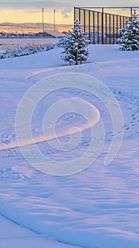 Vertical Snow covered landscape in Eagle Mountain Utah against a cloudy sunset