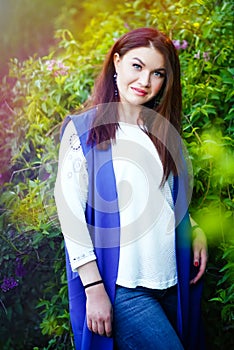 Vertical spring portrait of serious beautiful caucasian brunette 30 years old woman with fashionable makeup in purple lilac. Make-