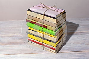 Vertical stack of different books tied with rope