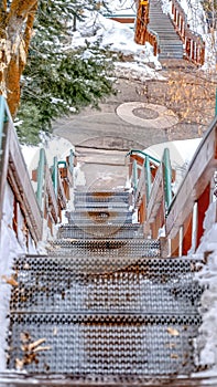 Vertical Stairway going down to a road on a hill with fresh white snow in winter