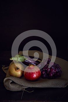 Vertical still life of eggplant and pomegranate