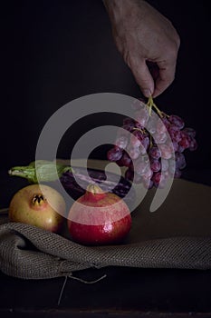 Vertical still life of eggplant and pomegranate