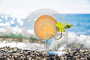 Vertical still life with oranges, peppermint and sea in the background