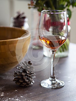 Vertical Still life wine in a glass on vintage wood table. Christmas or winter warming drink with pinecones around