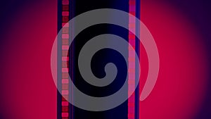 Vertical strip of blank film on a blue background with a red circular light close up. Processing negatives. Copy space.