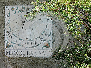 Vertical sundial timepiece of ancient times painted on a wall