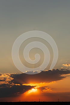 Vertical sunset shot with sun rays through thick clouds