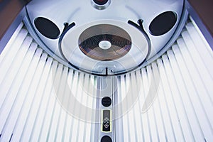 Vertical Tanning turbo Solarium Light Machine with glowing blue light ultraviolet lamps for tanning and skin care. Empty