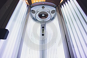 Vertical Tanning turbo Solarium Light Machine with glowing blue light ultraviolet lamps for tanning and skin care. Empty