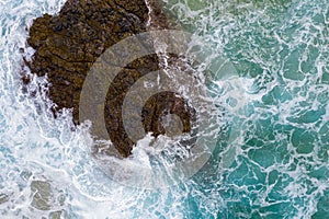 Vertical top down view of waves crashing over rocks on Lumahai beach on Kauai