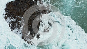 Vertical top down view of waves crashing over rocks on Lumahai beach on Kauai