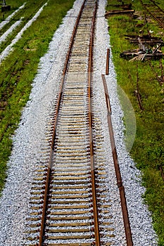 Vertical top of a train track with white small stones and grass around Paranapiacaba photo