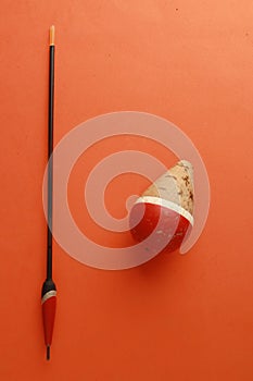 Vertical top view closeup shot of fishing float on an orange background