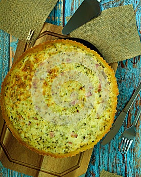Vertical top view of a delicious breakfast quiche on a wooden surfa