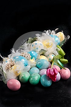 Easter, colored eggs with feathers, and a spring tulip