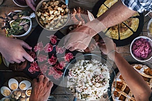 Vertical top view of friends eating together  on a wooden table full of food - friendship and celenration people - concept of