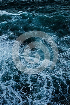 Vertical top view image of dark blue water with white foam in La Habana, Cuba photo