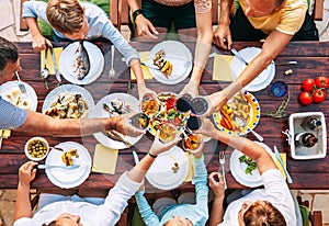 Vertical top view on served table and hands with clinking goblet