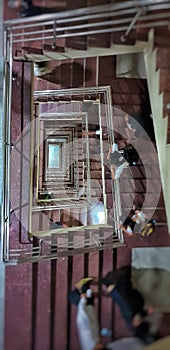 Vertical top view of the spiral staircase with people climbing home