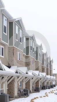 Vertical Townhome facade with snowy gabled roof at the entrance in winter