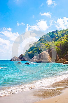 Vertical tropical landscape. Sea with a rocky shore and a mountain on a sunny day on a tropical island. Travel and