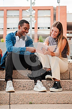 Vertical. Two multiracial teenage studens learning together at university campus. African american schoolboy talking