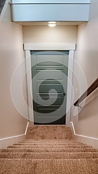 Vertical U shaped staircase that leads to the basement door from main floor of home