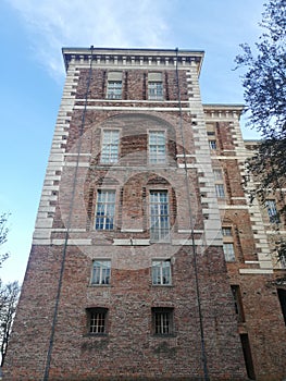 Vertical undershot of the  castle of Rivoli against a cloudy, sunlit sky background