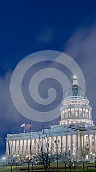 Vertical Utah State Capital Building glowing against sky and clouds in Salt Lake City