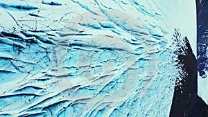 Vertical video: Aerial view of blue glacier rocks