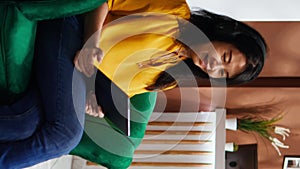 Vertical Video Asian woman checking webpages on tablet in hotel lobby