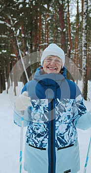 Vertical video, the camera zooms in on a happy woman of retirement age