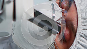 Vertical video: Close up of experienced biologist in ppe suit working on microscopes