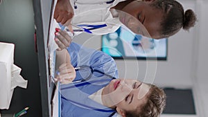 Vertical video: Diverse medical team working at hospital reception desk