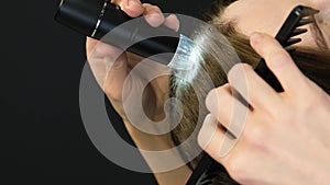 Vertical video. Examination of the patient's scalp by a trichologist using a flashlight and a comb.