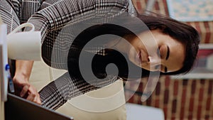 Vertical video Freelancing businesswoman concentrating on inputting data on laptop