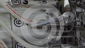 Vertical video glass bottles on a medical solution conveyor at filling station close up