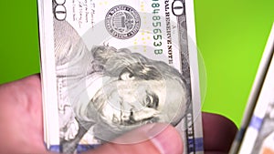 Vertical video of hand counts Wad of 100 american dollars money on blurry background. Cash banknotes close up vertical