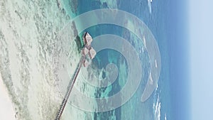 Vertical video house on stilts in the ocean on the coast of Zanzibar, Tanzania, aerial view